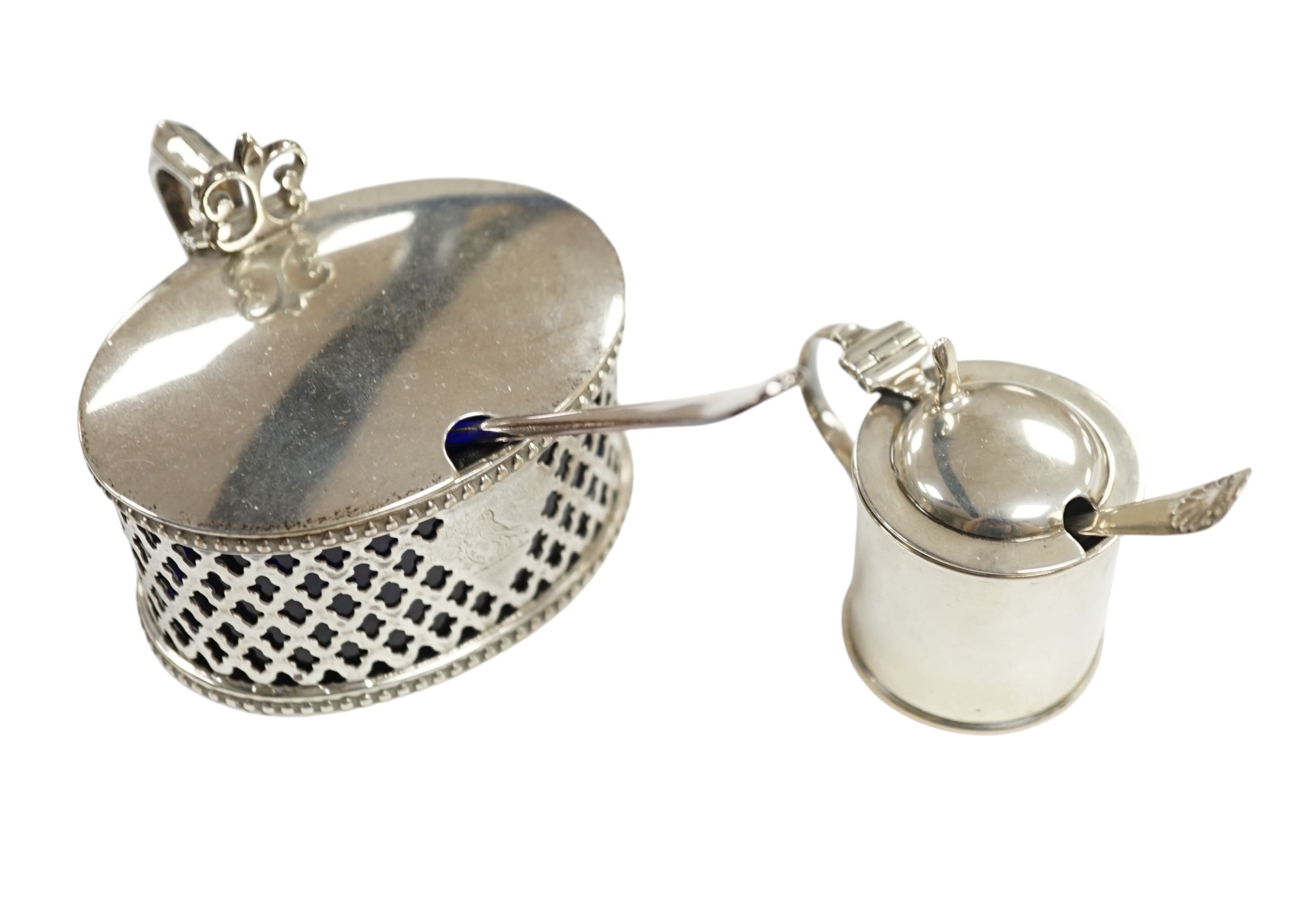 A Victorian pierced silver oval mustard pot by Henry Wilkinson & Co Ltd, Sheffield, 1851, 84mm, with blue glass liner and associated plated spoon, together with a smaller later silver mustard pot. Condition - fair